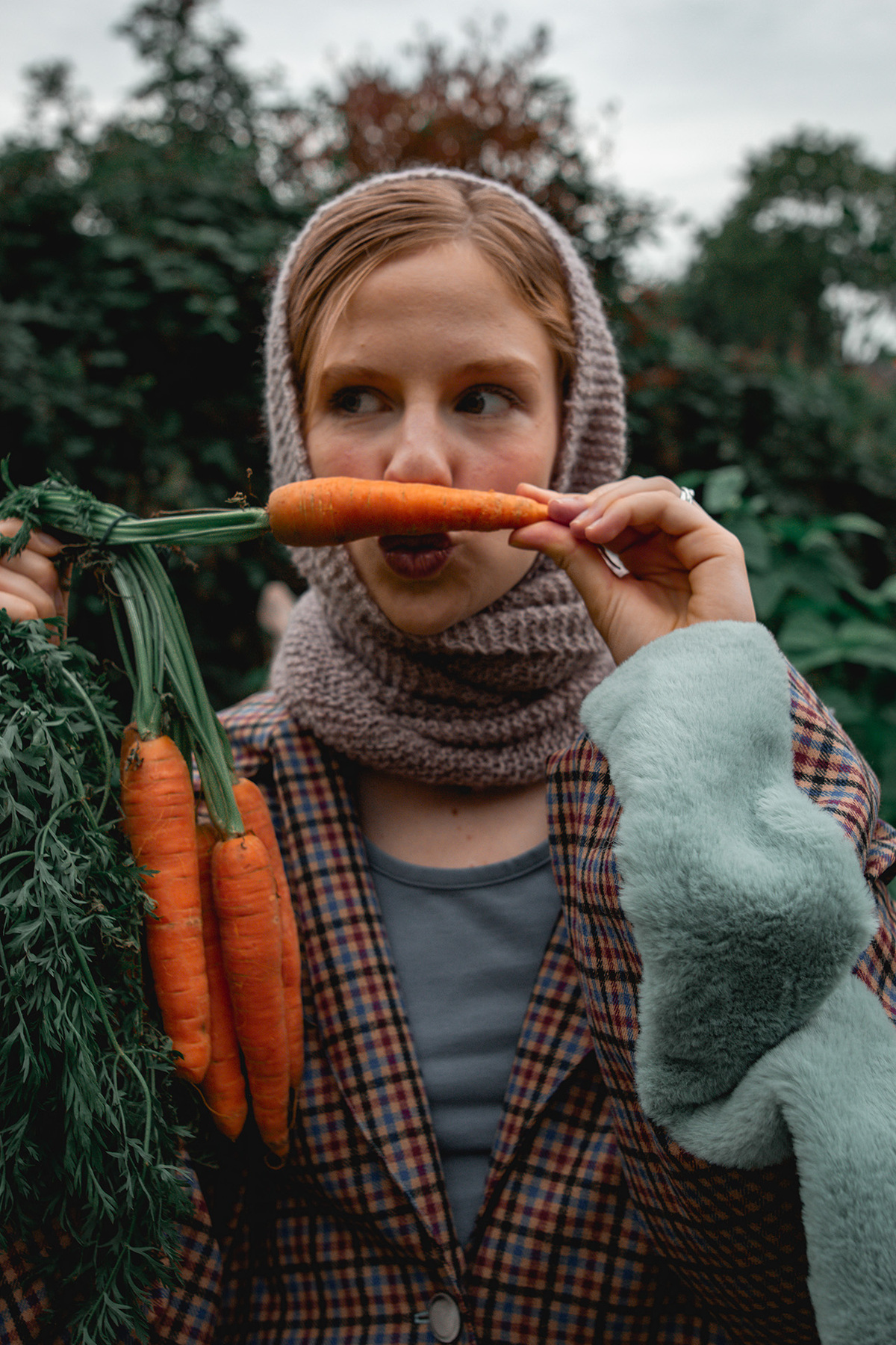 Model Holding A Carrot In Front Of Her Face